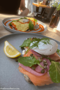 Plates of eggs and salmon lox for brunch displayed on a table in Midtown, NYC restaurant Hole in the Wall.