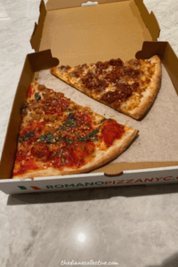 A box of Romano pizza from a Midtown NYC restaurant with two slices of pizza inside.